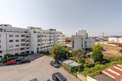 an apartment complex with cars parked in a parking lot at Bright Flat with Balcony & Garage by HostWise in Oliveira do Douro