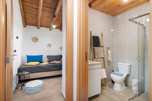a bedroom with a bed and a shower and a toilet at Casa Gotinha d' Água in Alcaria Ruiva