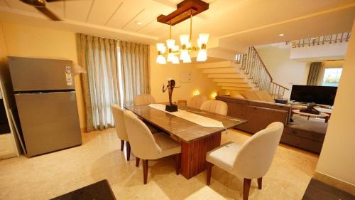 a kitchen and dining room with a table and chairs at Villa Paraiso by DanCenter | 4BHK Pvt Pool | Arpora in Goa