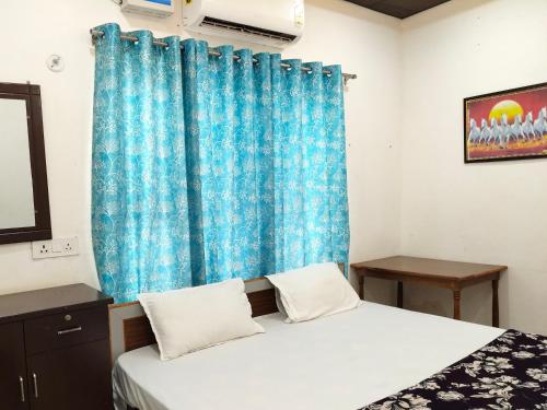 a bedroom with a bed and a blue curtain at B K Palace in Ayodhya