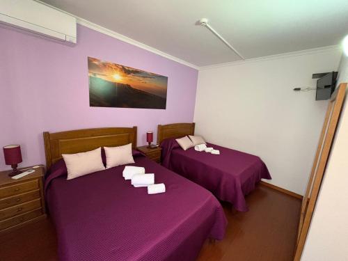 two beds in a room with purple sheets at Recanto do Açor in Vide