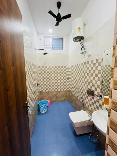 a bathroom with a toilet and a sink and a ceiling fan at Hotel Grand Central in Bulandshahr