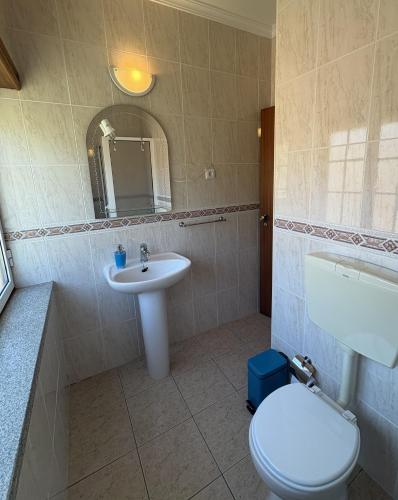 a bathroom with a white toilet and a sink at Recanto do Açor in Vide