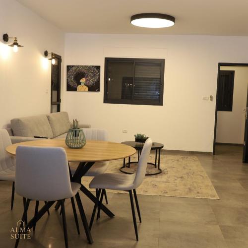 a living room with a wooden table and chairs at Alma suite in Ashdot Ya‘aqov