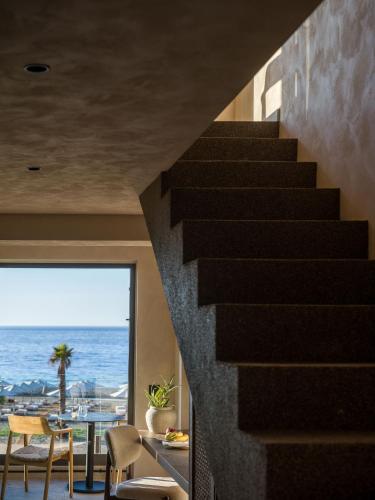 a staircase in a house with a view of the ocean at Nalu Resort & SPA Adults Only Hotel in Adelianos Kampos