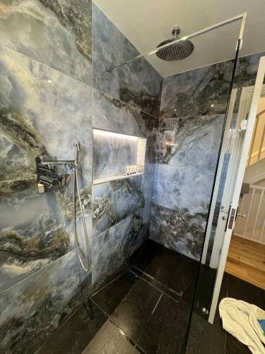 a bathroom with a shower with a stone wall at House in Watford