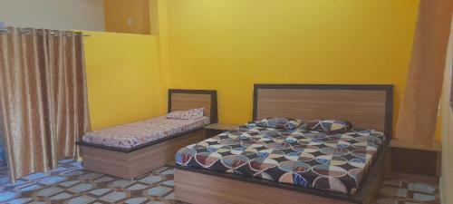 zwei Betten in einem Zimmer mit gelben Wänden in der Unterkunft Mountain View Farmstay in Matkuli