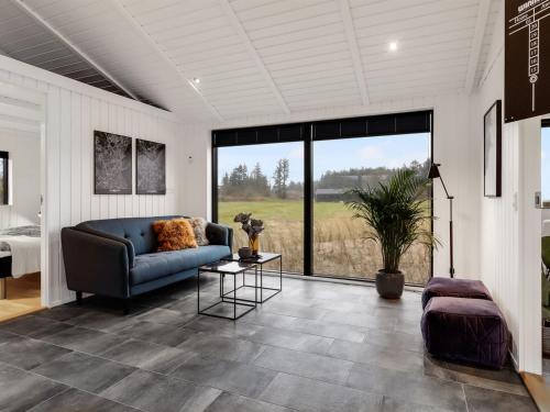 a living room with a couch and a large window at Holiday Home Sasja - 1-5km from the sea by Interhome in Hjørring