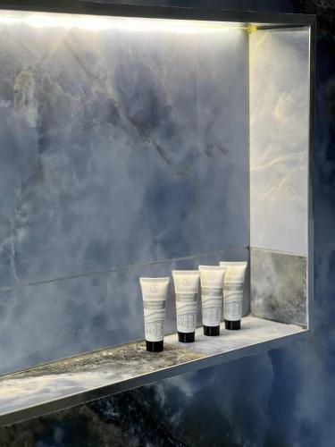 a shelf with four white cups on it at House in Watford
