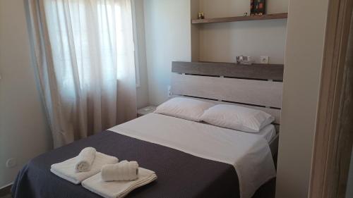 une chambre avec un lit avec deux serviettes dessus dans l'établissement Aspa, à Kalymnos