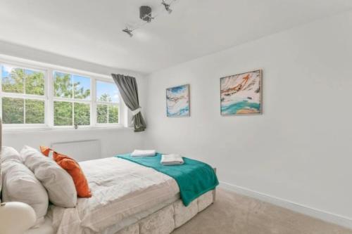 イルクリーにあるStylish home close to the Yorkshire Dales & Leeds Airportの白いベッドルーム(ベッド1台、窓2つ付)