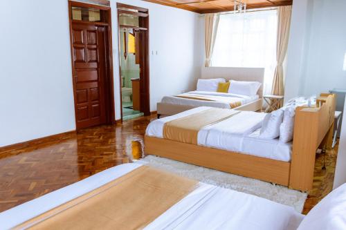 a room with two beds and a couch in it at Havan Guest House - Eldoret in Eldoret