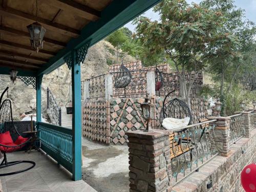 un patio con una valla, una mesa y sillas en Villa Tabori, en Tiflis