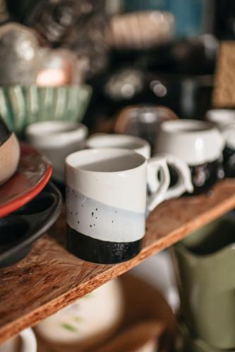 a group of coffee cups on a wooden shelf at Uroczysko Oleśnica in Chodzież