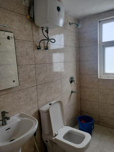 un baño con inodoro y lavabo en Eternity Grand Vrindavan, en Chhatikara