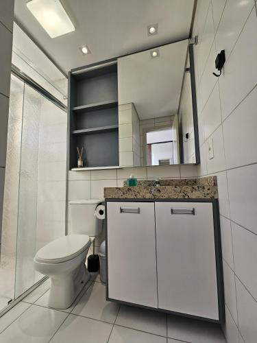 a white bathroom with a toilet and a mirror at Loft Centro Oktoberfest - Blumenau in Blumenau