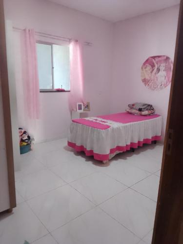 a bedroom with a pink bed in a white room at Casa dos sonhos in Viçosa do Ceará