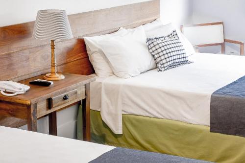 a bedroom with a bed and a table with a lamp at Hotel Resort e Golfe Clube dos 500 in Guaratinguetá