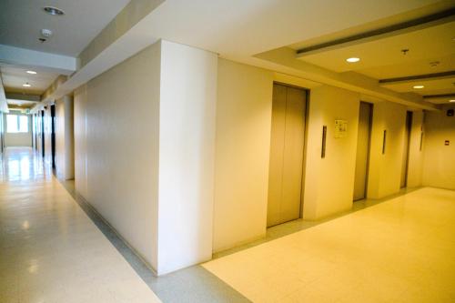 a hallway of a building with white walls and tile floors at Centrio Tower Cozy 1 Bedroom with City View in Cagayan de Oro