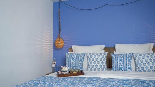 a blue bedroom with a bed with blue and white pillows at Mizpah Delhi in New Delhi
