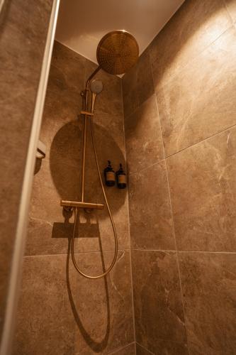 a shower with a shower head in a bathroom at Arnbjerg Pavillonen in Varde