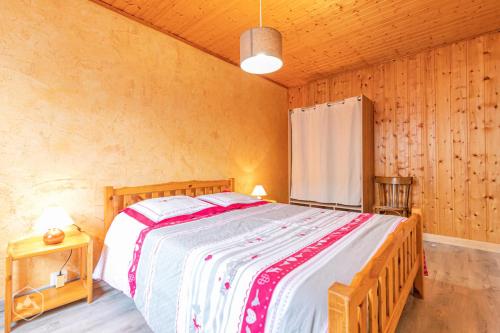 a bedroom with a large bed in a room with wooden walls at Résidence Arnaud Nicole - Appartement très spacieux au coeur du village MAE-0723 in Aussois