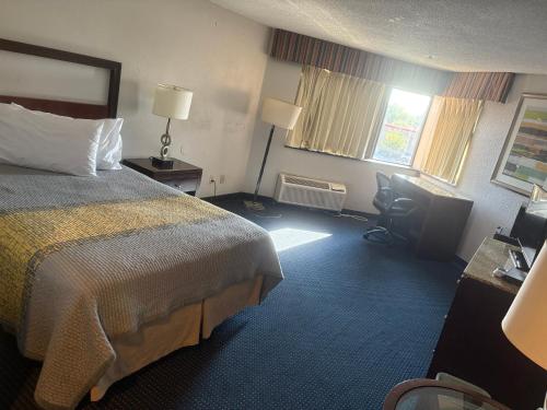 a hotel room with a bed and a desk at Apm Inn & Suites in Hagerstown