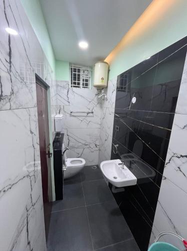 a bathroom with two sinks and black and white marble walls at Siruvani Residency - Near Isha Foundation Coimbatore in Alāndurai