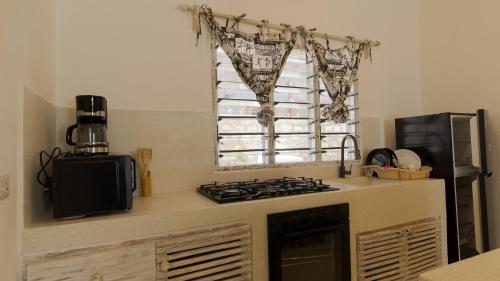 a kitchen with a stove top oven next to a window at Rafiki Tamu Residential Resort in Watamu