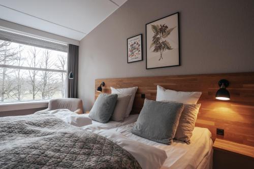 a bedroom with a large bed and a window at Arnbjerg Pavillonen in Varde