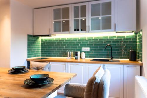- une cuisine avec une table en bois et du carrelage vert dans l'établissement Castelului Boutique-Old Town-Free Private Parking, à Braşov