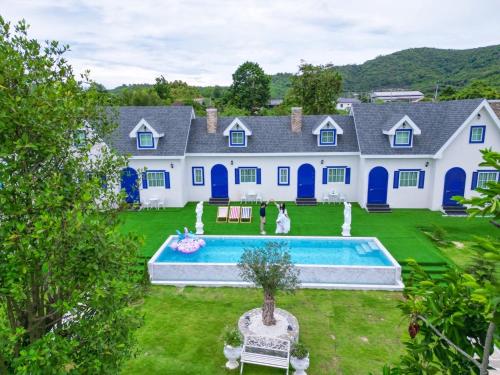 a large white house with a pool in the yard at Britishhillresort สัตหีบ บางเสร่ ช่องเเสมสาร in Ban Tao Than