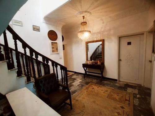 a hallway with a staircase and a chair and a mirror at Hotel Rise Inn in Karachi