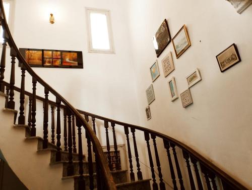 a stairway with pictures on the wall at Hotel Rise Inn in Karachi