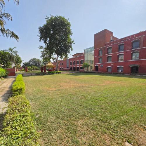 a grassy field in front of a brick building at The Sky Imperial, Gandhinagar in Gandhinagar