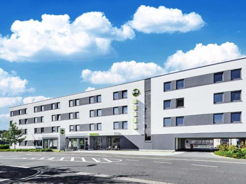 a white building with a sign on the side of it at B&B Hotel Aschaffenburg in Aschaffenburg