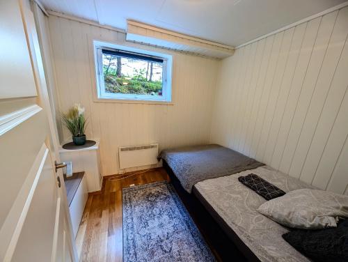 トロムソにあるAurora rooms in shared hsuse nr3 we are doing Northen Lights trip, Reaindear trip and Sommaroy Fjord tripsのベッドが2つと窓がある小さな部屋