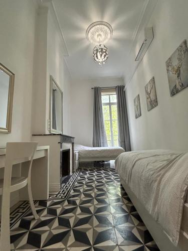 a bedroom with a bed and a desk and a fireplace at Appartement Avenue Feuchères Arènes in Nîmes