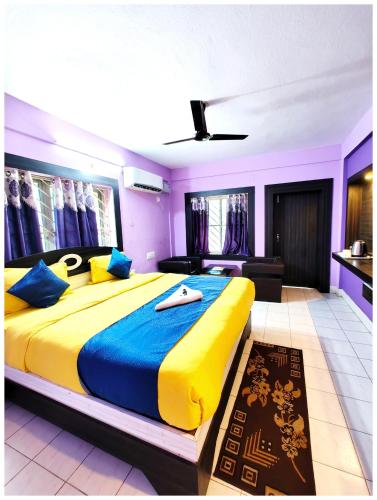 a bedroom with a large bed with yellow and blue sheets at Hotel Pioneer Ashish Near Sea Beach And Jagannath Temple - Fully Air Condition with All Luxury # Luxuary Rooms With Attached-Balcony #wifi-Restaurant And Parking Facilities# Boutique Services - Top Hotel In Puri in Puri