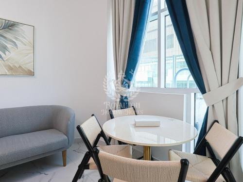a living room with a table and chairs and a window at Royalton - Private Pool Luxe Studio in Dubai in Dubai