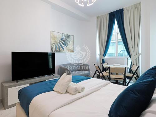 a bedroom with a large bed with a flat screen tv at Royalton - Private Pool Luxe Studio in Dubai in Dubai