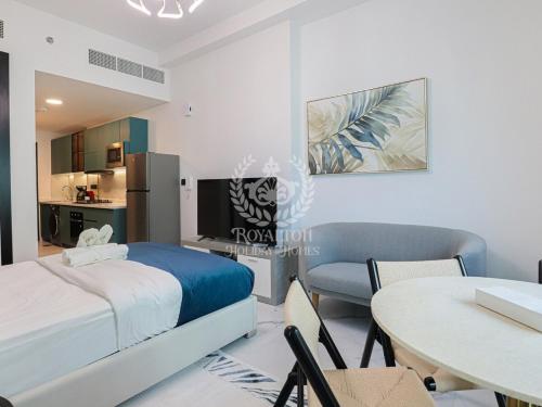 a bedroom with a bed and a table and a kitchen at Royalton - Private Pool Luxe Studio in Dubai in Dubai