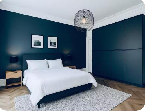 a blue bedroom with a white bed and a blue wall at Lodge - Sleeps 18 pet friendly & free parking in Ravensworth
