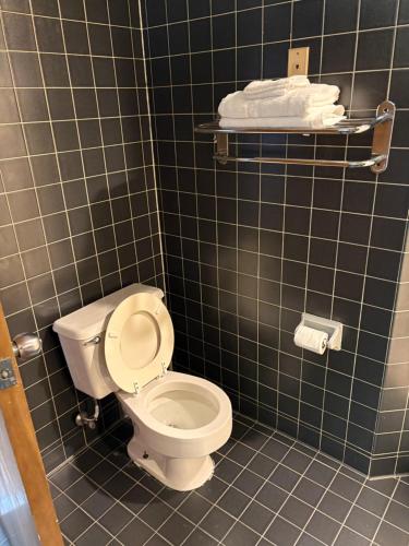 a bathroom with a toilet and a tiled wall at Apm Inn & Suites in Hagerstown