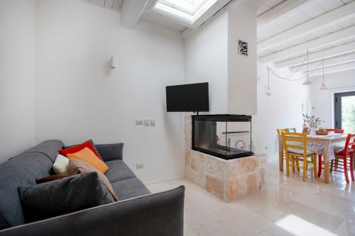 a living room with a couch and a fireplace at Trulli di Titti - Luxury Country House in Castellana Grotte