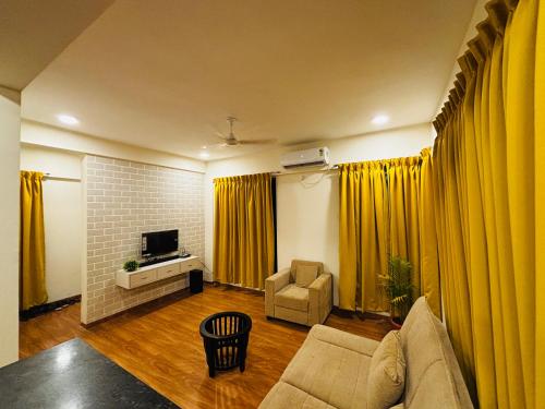 a living room with yellow curtains and a couch at City Of Music - Nirvana in Pali