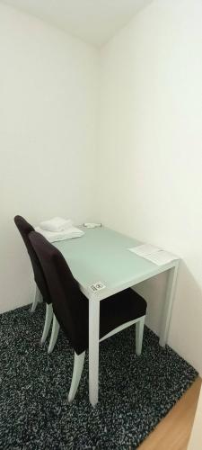 a white desk with a black chair next to a wall at Holunder Inn in Menziken