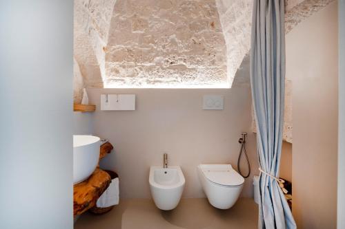 a bathroom with a toilet and a sink at Trulli di Titti - Luxury Country House in Castellana Grotte