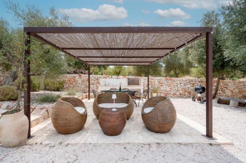 a pergola with a table and chairs under it at Trulli di Titti - Luxury Country House in Castellana Grotte