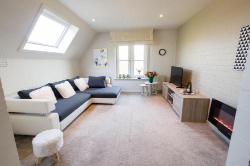 a living room with a couch and a tv at SHAMBALLA logies nieuw en zeer verzorgd appartement met voortuin en terras in Deinze